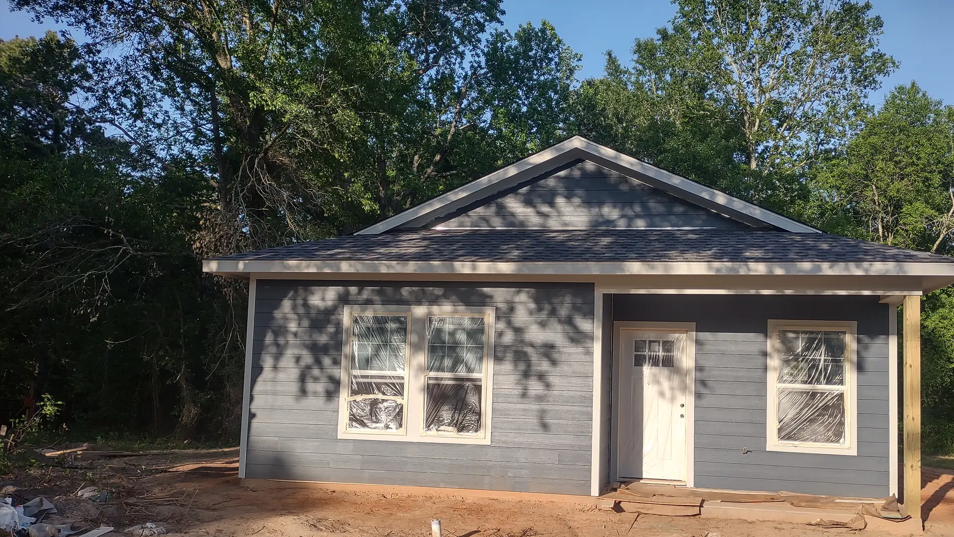 A newly built home with blue-gray siding and white trim in East Texas, built by SMG United Contractors