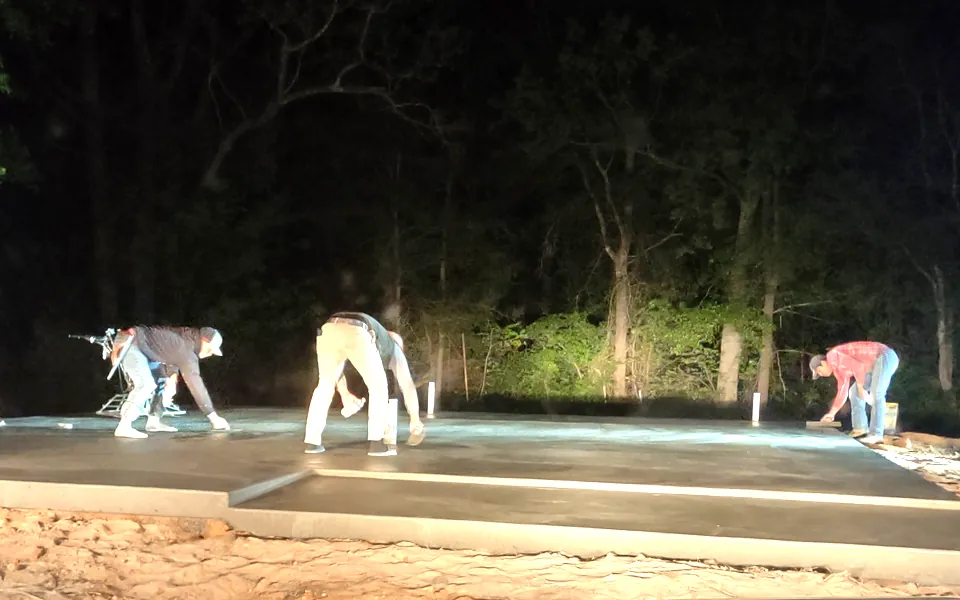 SMG crew finishing a concrete slab foundation at night