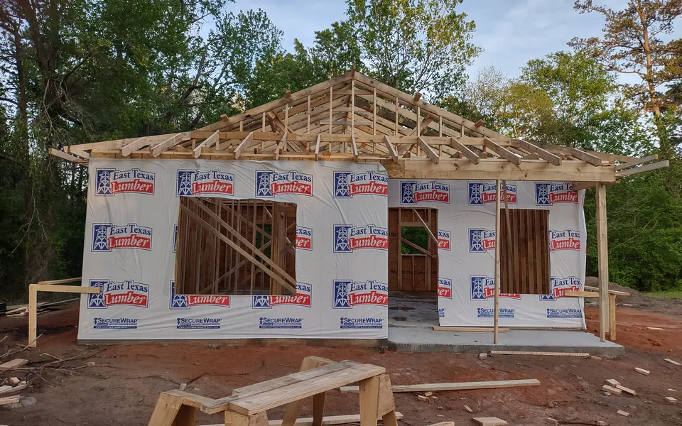 House frame with roof trusses set and the walls wrapped